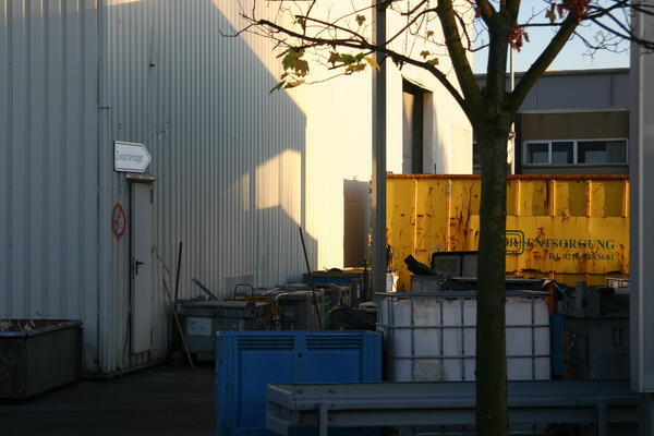 Bild vergrößern: Container verschiedener Größe stehen in einem Hof mit einem Hinweisschild: "Zwischenlager".