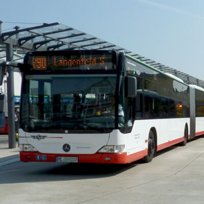 Bild vergrößern: Ein Gelenkbus der Linie 490 Richtung Langenfeld Bahnhof steht an einem überdachten Haltestellensteig.