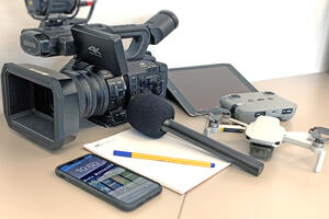 Bild vergrößern: Eine Videokamer, ein Smartphone, ein Tablet und eine Drohne.
