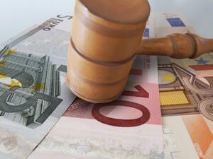 Bild vergrößern: Ein Richterhammer liegt auf einem 5-, 10- und 50-Euro Geldschein.