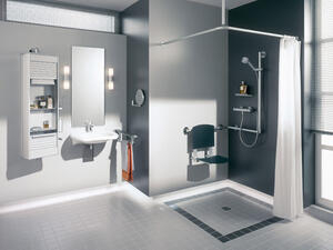 Bild vergrößern: Links ein Waschbecken mit Wandspiegel, rechts eine ebenerdige Dusche.