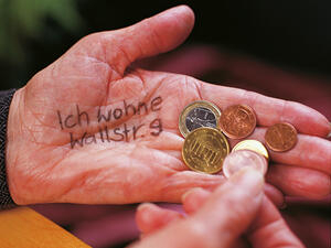 Bild vergrößern: Eine Hand zählt Kleingeld auf einer ausgestreckten Hand, auf welcher "Ich wohne Wallstr. 9" geschrieben steht.
