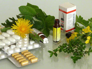 Bild vergrößern: Medikamentenblister und Medikamentenfläschen liegen auf einem Tisch.