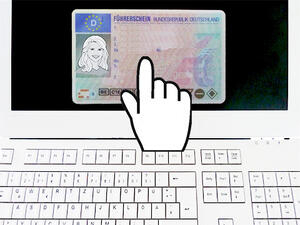 Bild vergrößern: Eine Hand zeigt auf das Bild eines Führerscheins auf einem Computerbildschirm.