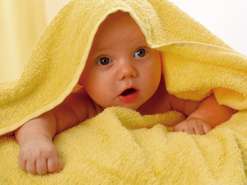 Baby in gelbem Handtuch