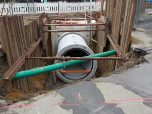 Bild vergrößern: Rohrleitungen in einem sich in Bau befindenden Kanalisation in einem abgesperrten Straßenbereich.