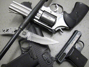 Bild vergrößern: Zwei Schusswaffen, ein Revolver, ein Messer und ein Schlagstock liegen aufeinander.