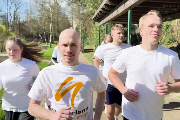 Bild vergrößern: Mehrere Läuferinnen und Läufer joggen durch einen Park. Sie tragen T-Shirts mit dem neanderland Cup Logo.
